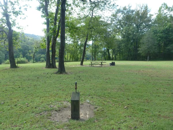 A water hydrant and two campsites with picnic tables and fire rings at Rush Campground. - NPS
