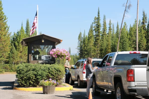 vehicles waiting to pay camping fees at entrance booth to campground - NPS Photo / A. Mattson