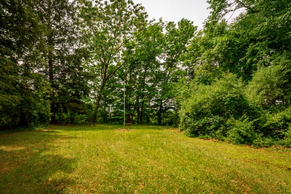 Image of an open area with a flag pole in the center and some small benches behind. - NPS Photo / Michael Cuff