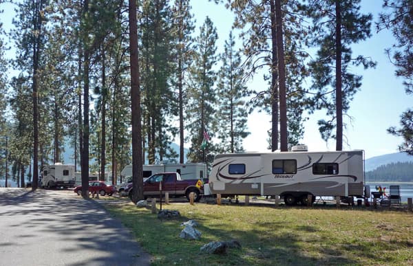 Large RV parked in campsite among ponderosa pine trees with other RVS in background - NPS Photo