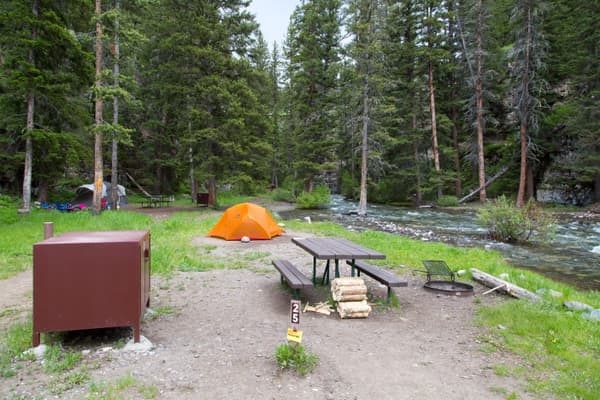 Food storage box, picnic table, tent at campsite. - NPS / Neal Herbert