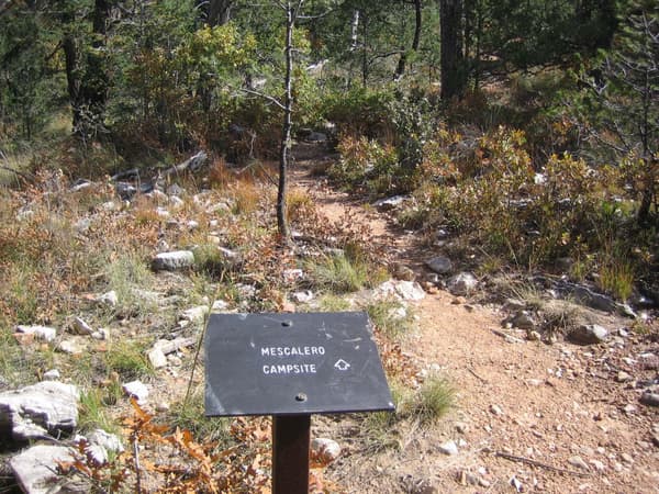A metal sign directs hikers off the trail to the Mescalero campsites - NPS/Bieri